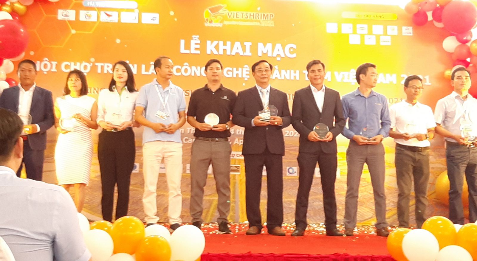 Ông Nguyễn Hữu Đức (ở giữa) giám đốc nhà máy VIETVET lên nhận kỷ niệm chương từ ban tổ chức Hội chợ Triển lãm Quốc tế ngành tôm Việt Nam (VIETSHRIMP) 2021